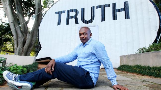 willis thomas poses in front of inflatable truth booth